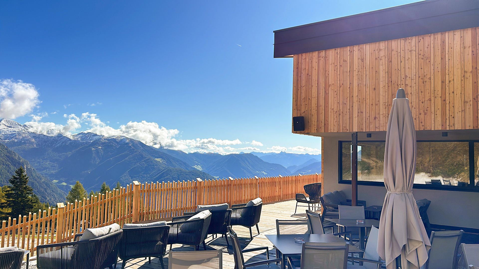 Panoramaterrasse in den Bergen mit Blick auf die Alpen und Outdoor-Loungebereich.