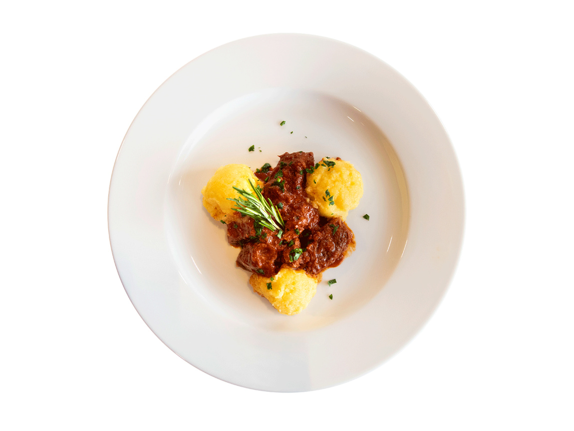 Spiegeleier mit knusprigem Speck, serviert auf einem weißen Teller mit Saucen- und Gemüsedekoration